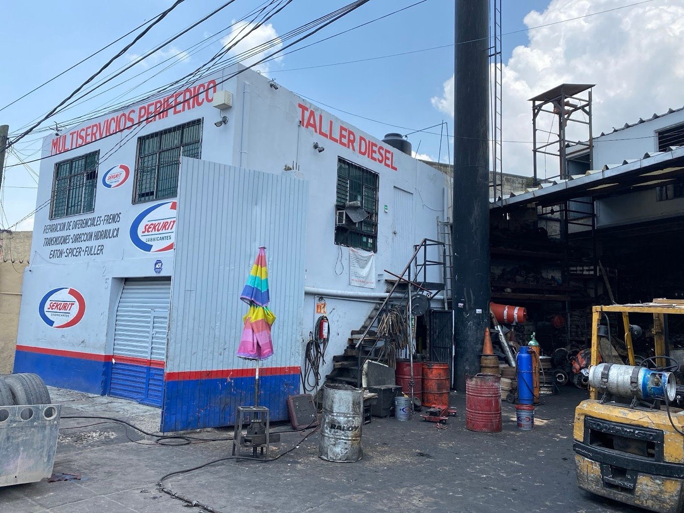 Patio del taller con montacargas y unidades en servicio